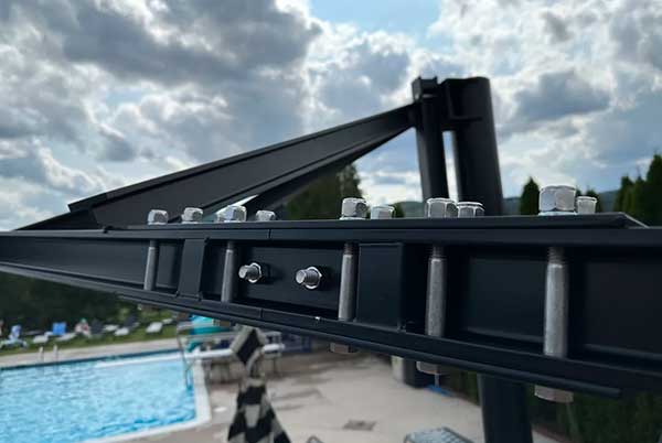 Made with structural steel and aluminum, this surface-mount shade sail stands up to wind.
